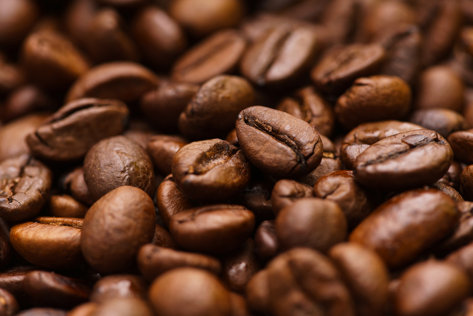 Detail view of roasted coffee beans, with out of focus background.